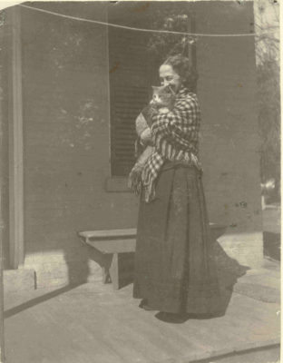 black and white photograph of Lavinia Dickinson wearing a checkered shawl and holding a cat