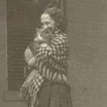 black and white photograph of Lavinia Dickinson wearing a checkered shawl and holding a cat