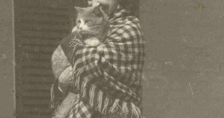 black and white photograph of Lavinia Dickinson wearing a checkered shawl and holding a cat