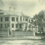 White house captured from North Pleasant Street with a fence in front