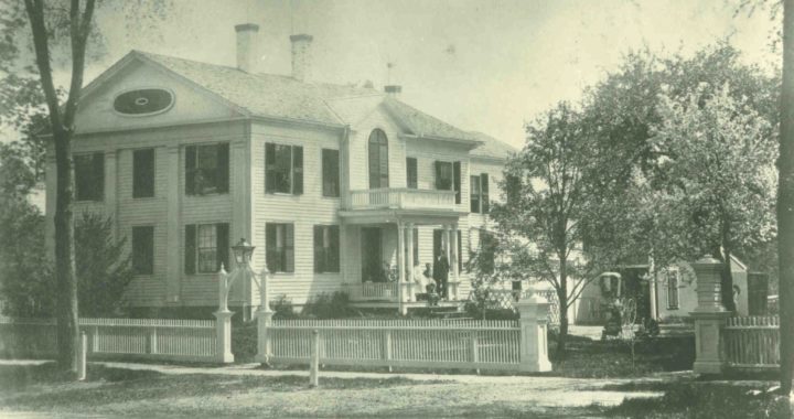 White house captured from North Pleasant Street with a fence in front