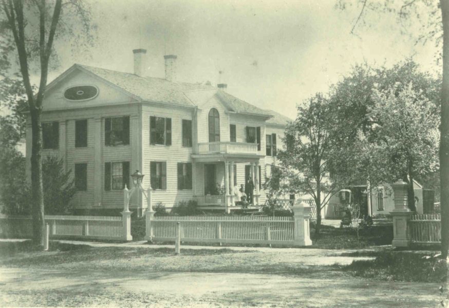 White house captured from North Pleasant Street with a fence in front