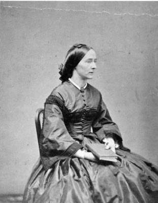 black and white photograph of a seated woman in 1860s clothing