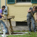 Two volunteers dig in the garden at the Emily Dickinson Museum