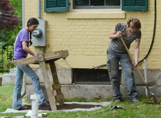 Two volunteers dig in the garden at the Emily Dickinson Museum