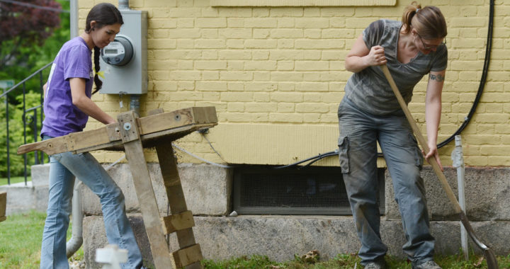 Two volunteers dig in the garden at the Emily Dickinson Museum