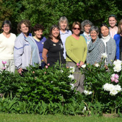 Group of people standing in a garden on the grounds of the museum