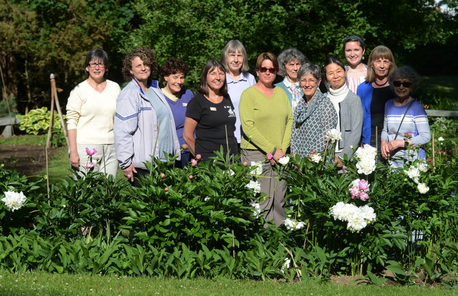 Group of people standing in a garden on the grounds of the museum