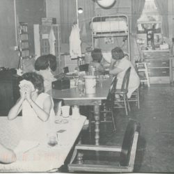 black and white photo of incarcerated women playing cards.