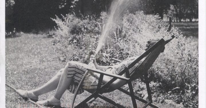 Black and white postcard depicting a photograph of Eudora Welty sitting outside by a sprinkler and a garden