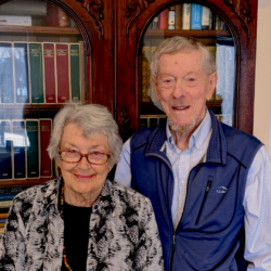 Photo of donors John and Elizabeth Armstrong standing in front of a bookshelf