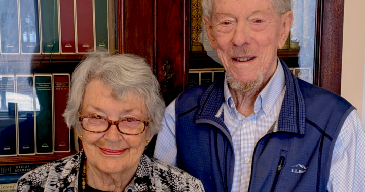 Photo of donors John and Elizabeth Armstrong standing in front of a bookshelf