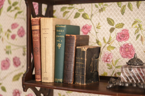 close-up of a shelf in Dickinson's bedroom with a few books and an inkwell