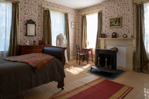 Dickinson's bedroom with the bed, desk and white dress