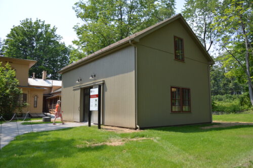 A woman walks into the recently completed carriage house on a sunny day