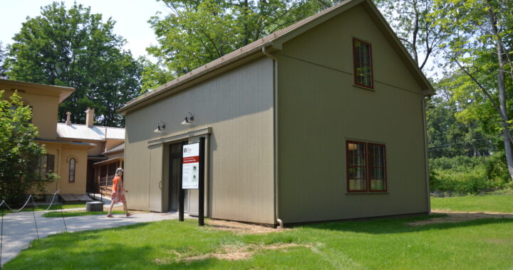 A woman walks into the recently completed carriage house on a sunny day