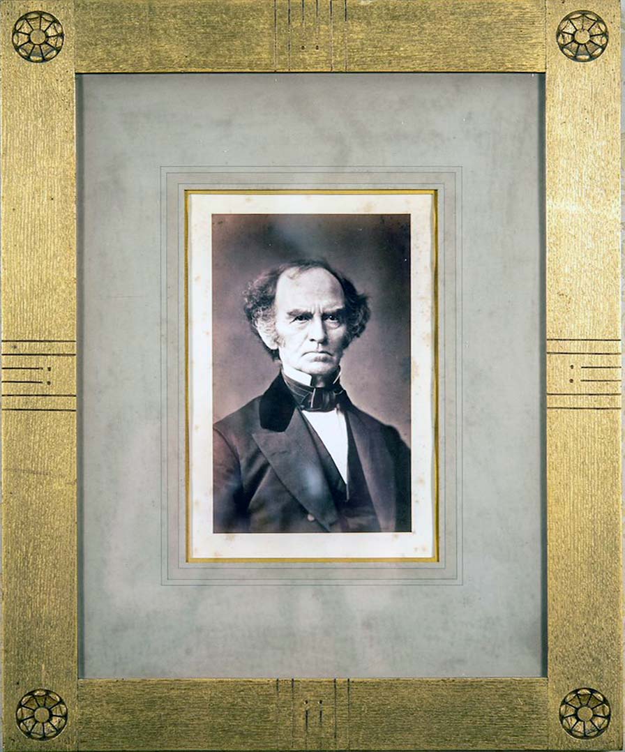 Gilt framed  portrait of a mature man, Edward Dickinson, wearing a dark suit and necktie. He has a severe expression.