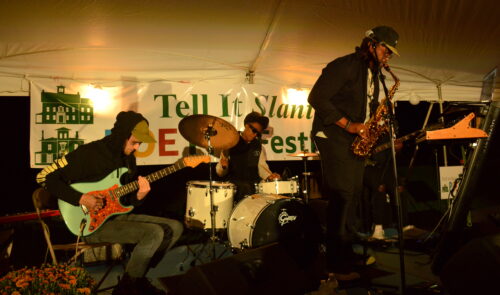 a saxophonist, drummer and guitarist perform at the 2022 Tell It Slant Poetry Festival