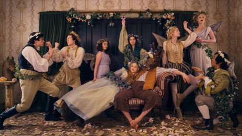 The cast of Apple TV's Dickinson in the parlor wearing Shakespearean costumes and florals