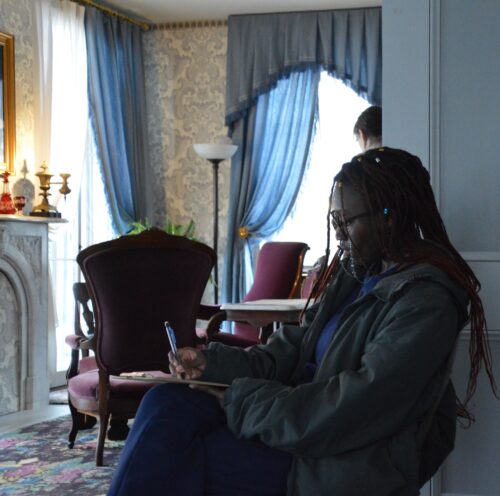 student writing in the parlor