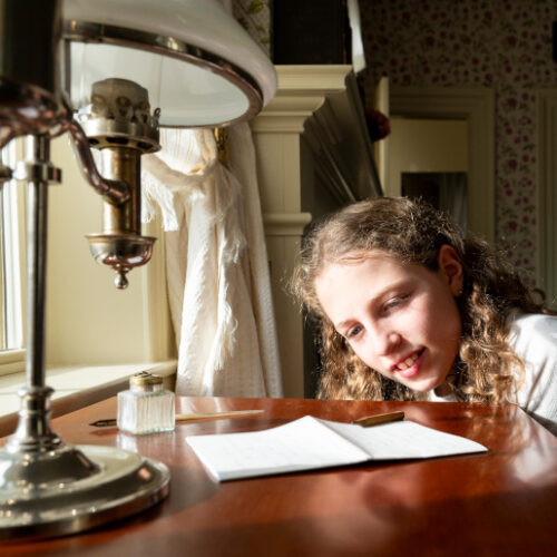 Students look at a poem on Emily's desk