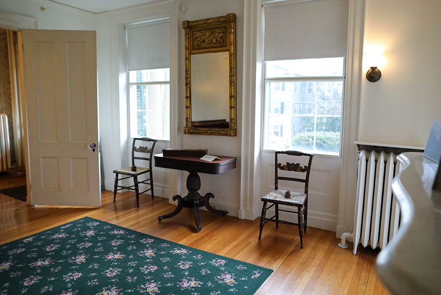 Facing the south windows of the parlor, the door to the entryhall at right beckons.