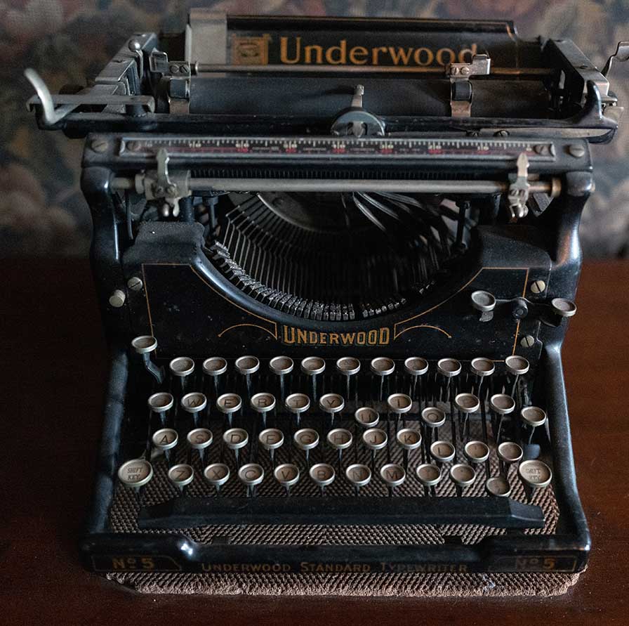 A black typewriter with four rows of round keys, labeled “Underwood Standard Typewriter No. 5.”