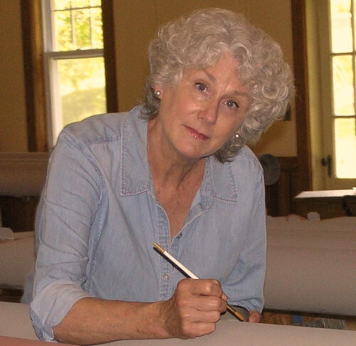 Marylou Davis is seated and painting an organ panel.