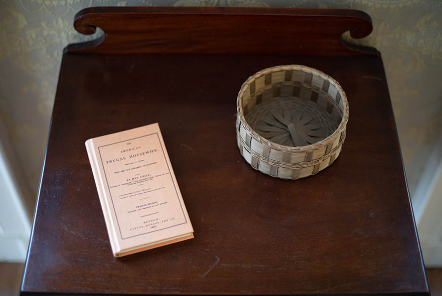 Yellow volume sits alongside a small sewing basket on a wooden table.