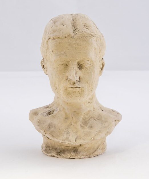 Plaster bust of Edward Austin "Ned" Dickinson shown head on. Surface is rough with scratches and fingermarks from sculpting