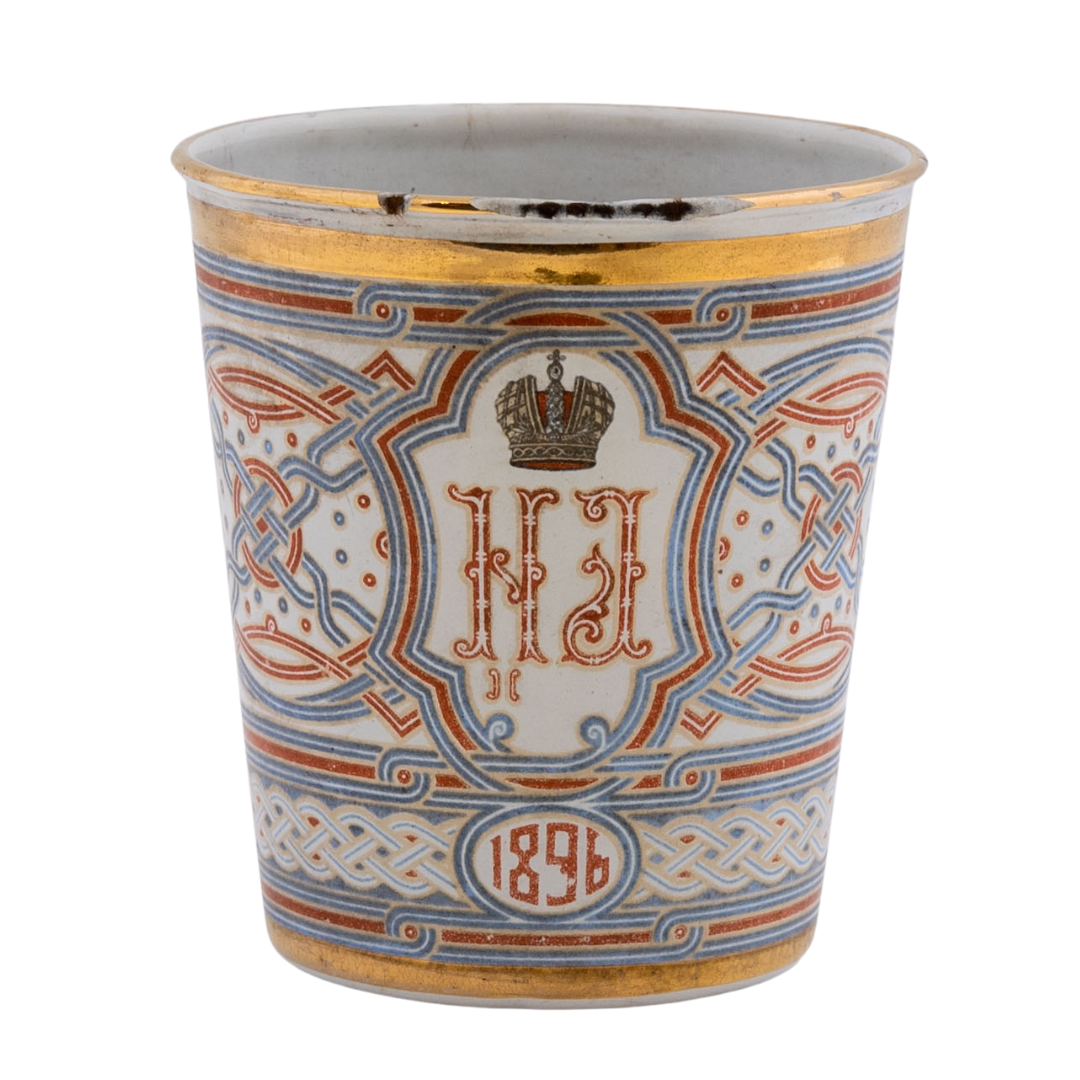 An enamel cup featuring the initials of Tsar Nicholas II and Tsarina Alexandra of Russia and the Romanov eagle.