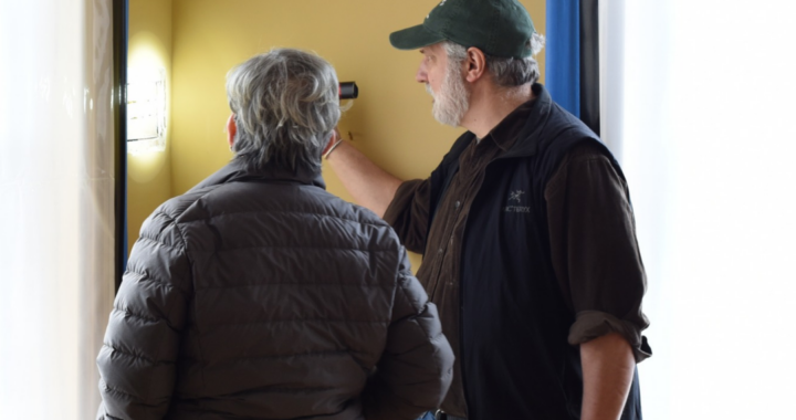 two people are looking into a square cutout carved out of the plaster of the walls at the Dickinson Homestead
