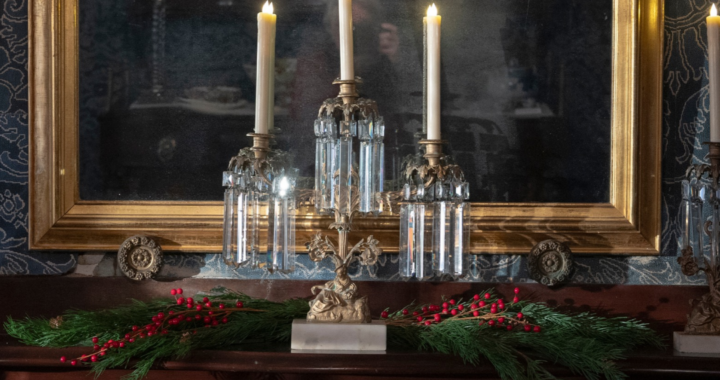 three candles sit on the mantle in The Evergreens