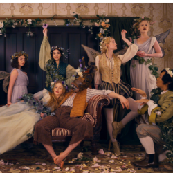 The cast of Apple TV's Dickinson in the parlor wearing Shakespearean costumes and florals