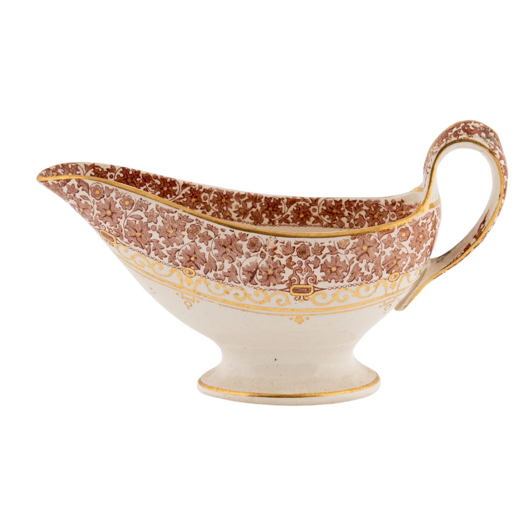 A beautiful sauce bowl trimmed with gold and a floral design.