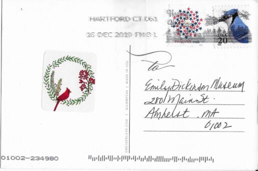 Postcard verso featuring a sticker of a cardinal sitting in a wreath