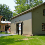a woman walks into the newly reconstructed carriage house