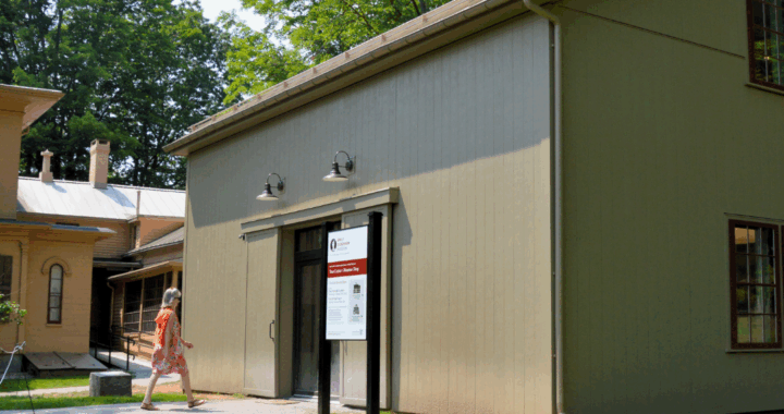 a woman walks into the newly reconstructed carriage house