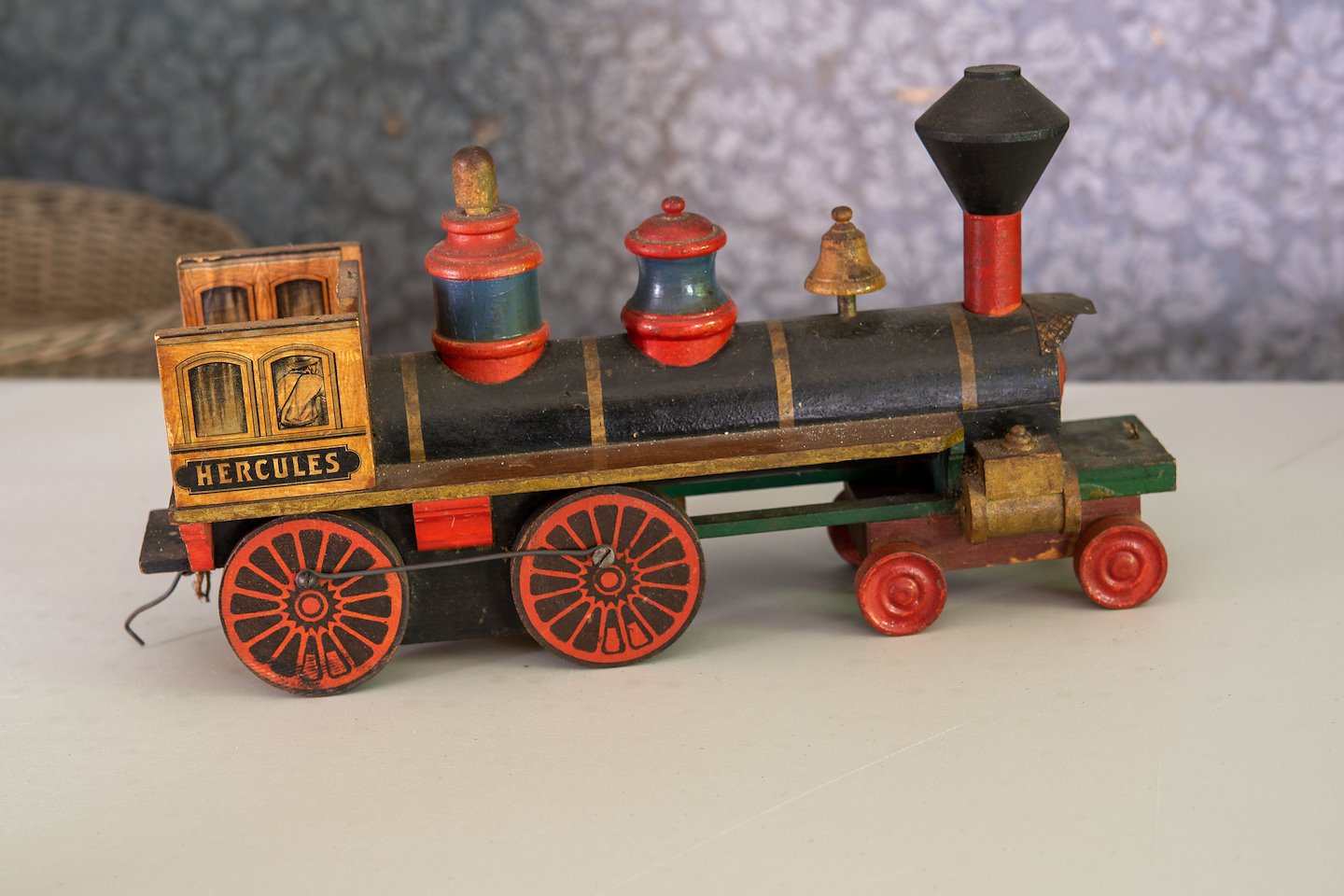 Wooden toy in the style of an 1800’s train engine with the word HERCULES printed on the conductor’s cab